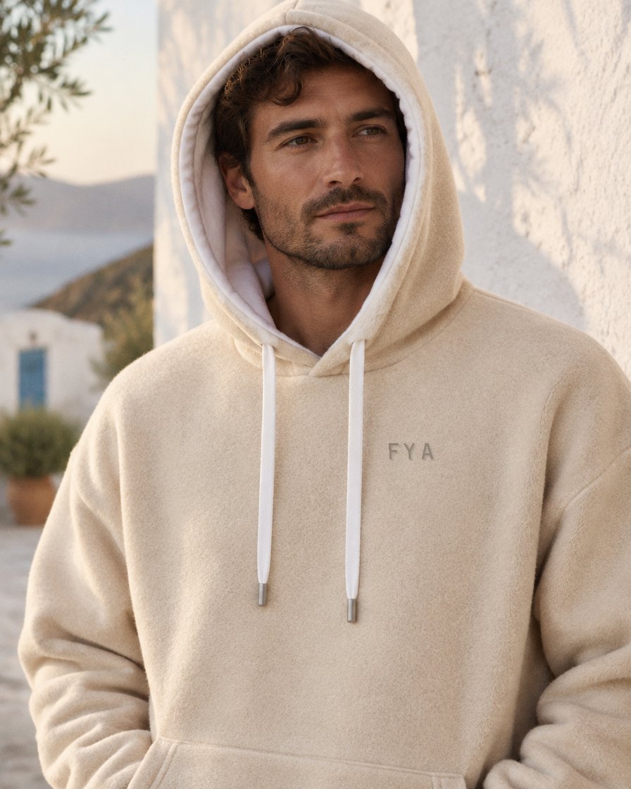 De crème hoodie gedragen met capuchon op