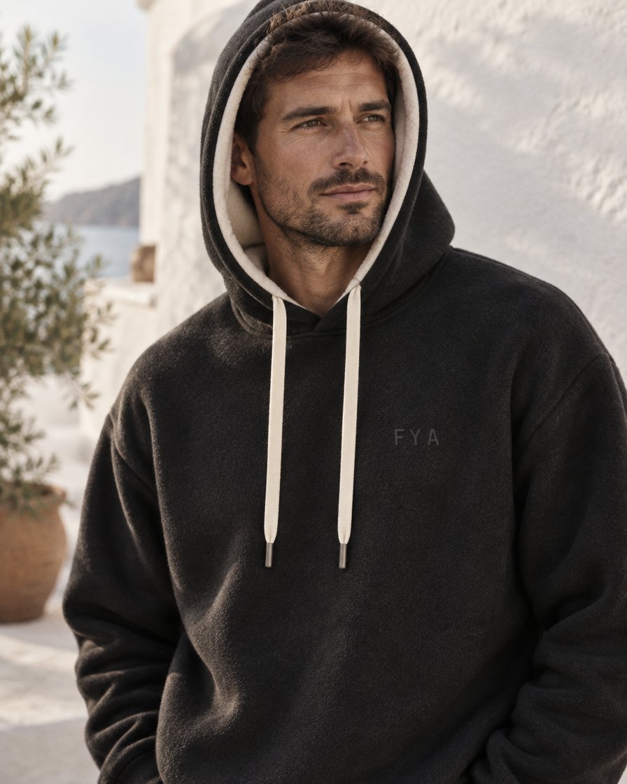 Man met de zwarte FYA hoodie op, crème capuchonvoering zichtbaar